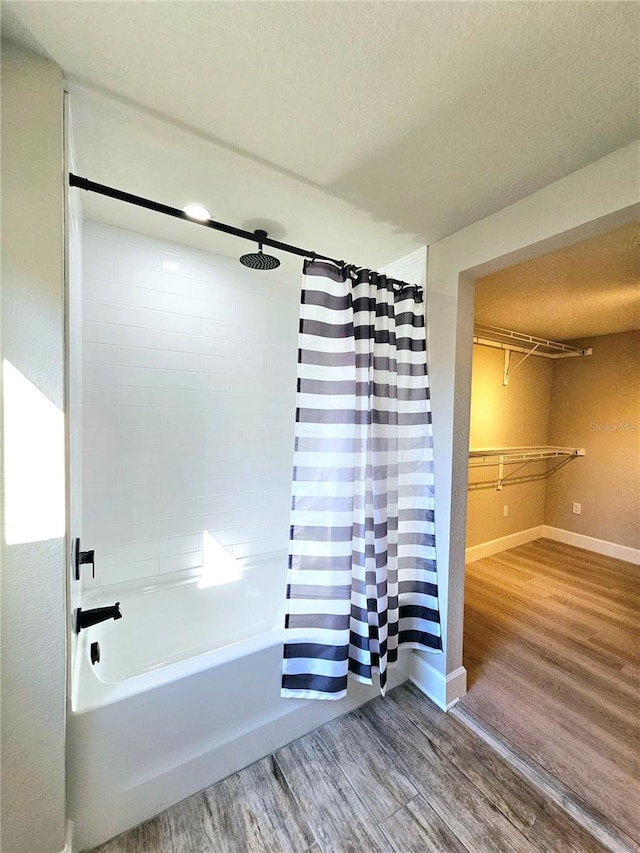 13633 Britton Dr, Hudson, FL 34667 - full bathroom featuring shower / bath combination with curtain, a textured ceiling, baseboards, and wood finished floors