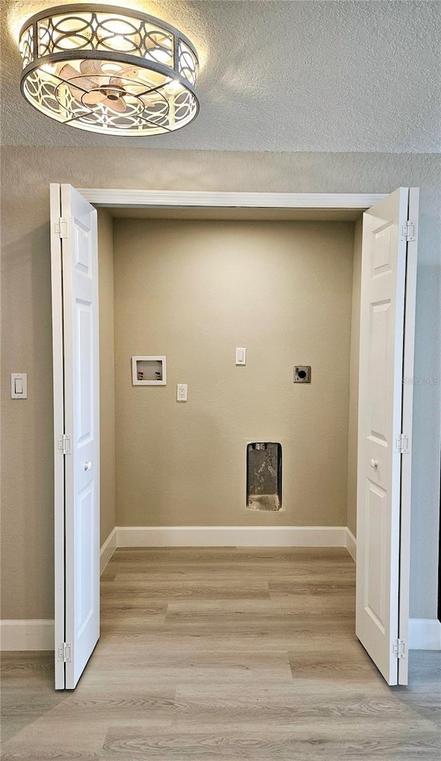 13633 Britton Dr, Hudson, FL 34667 - clothes washing area featuring laundry area, light wood-style floors, a textured ceiling, hookup for an electric dryer, and baseboards