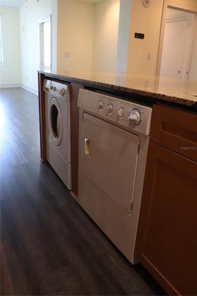 laundry room with laundry area, dark wood-type flooring, and washer and clothes dryer