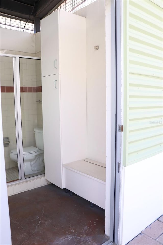 bathroom with concrete flooring and toilet