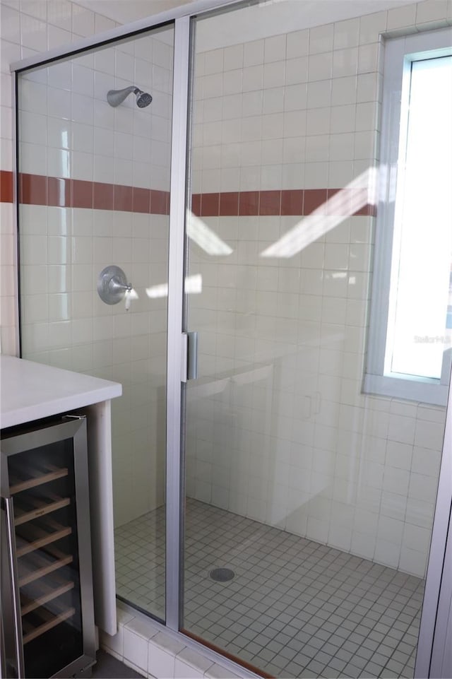 full bathroom featuring wine cooler and a shower stall