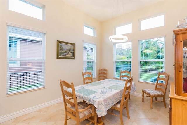 dining area featuring baseboards and a high ceiling