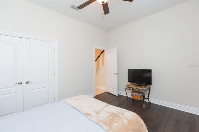 bedroom featuring a closet, visible vents, baseboards, and wood finished floors