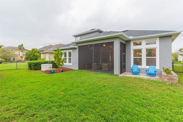 back of property with stucco siding, a lawn, fence, a sunroom, and a patio area