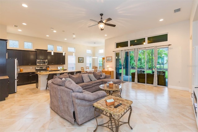 living area featuring visible vents, recessed lighting, a ceiling fan, and baseboards