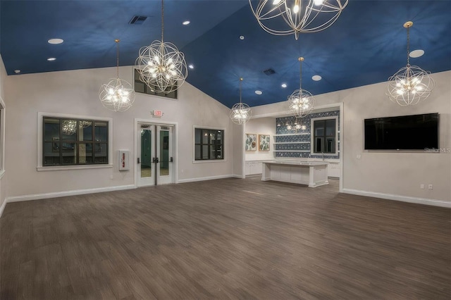 unfurnished living room featuring visible vents, baseboards, an inviting chandelier, dark wood-style floors, and high vaulted ceiling