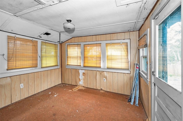 unfurnished sunroom featuring vaulted ceiling and plenty of natural light