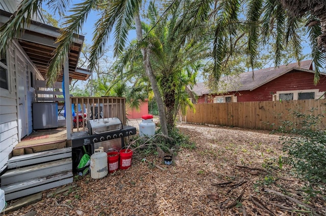 view of yard featuring a wooden deck and fence