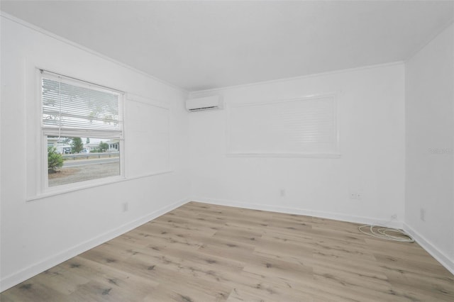 unfurnished room featuring light wood-style flooring, a wall mounted AC, baseboards, and ornamental molding