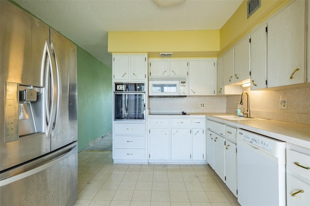 kitchen with visible vents, backsplash, light countertops, black appliances, and a sink