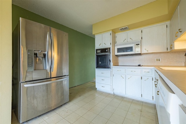 kitchen featuring visible vents, a sink, white cabinetry, white appliances, and light countertops