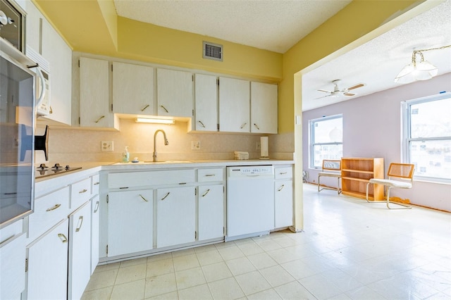 kitchen with visible vents, dishwasher, light countertops, a wealth of natural light, and a sink