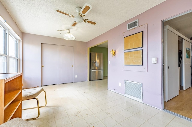 interior space with a ceiling fan and visible vents