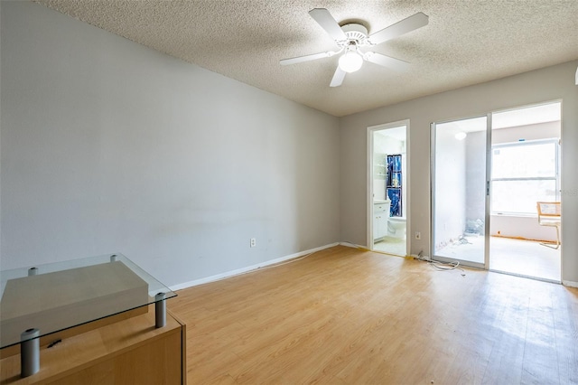 empty room with ceiling fan, baseboards, a textured ceiling, and light wood-style flooring