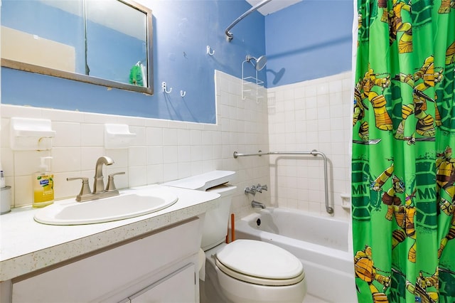 bathroom with vanity, shower / bathtub combination with curtain, a wainscoted wall, tile walls, and toilet