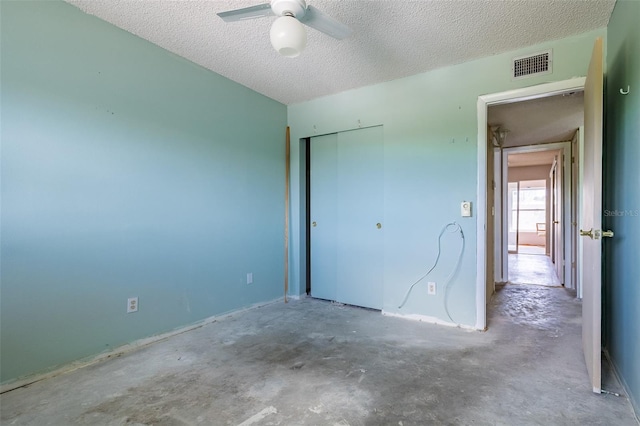 unfurnished bedroom featuring unfinished concrete floors, visible vents, a closet, and a textured ceiling