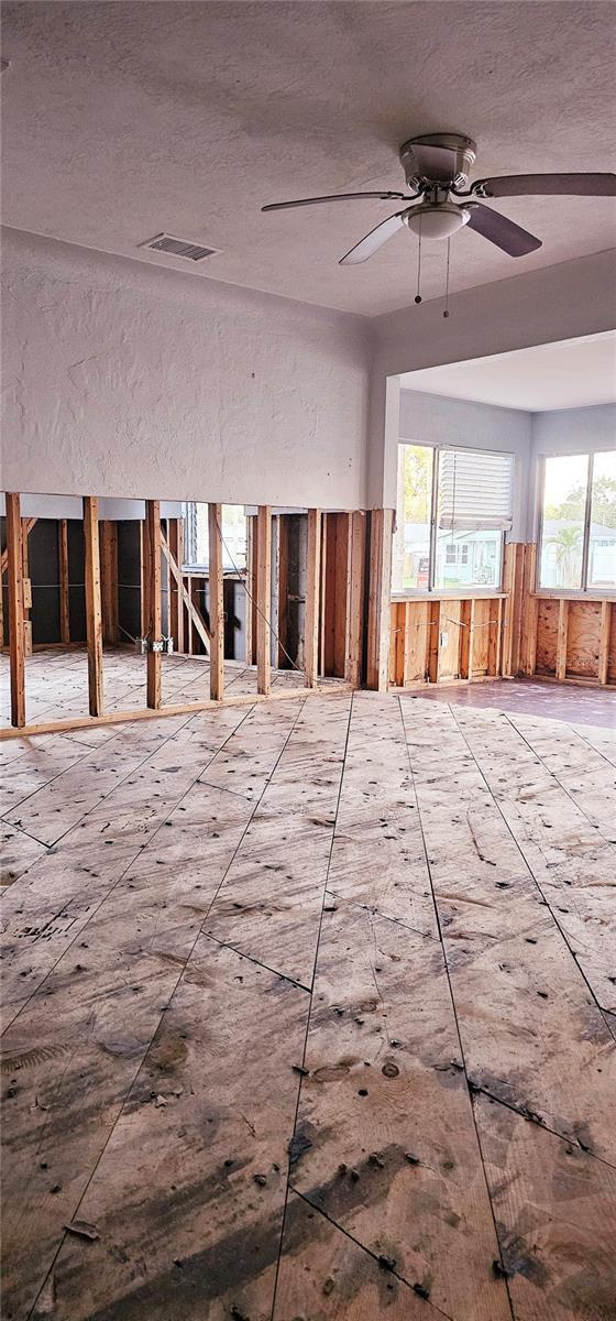 misc room with visible vents, a textured ceiling, and a ceiling fan