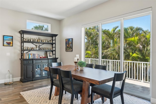 dining area featuring baseboards and light wood finished floors