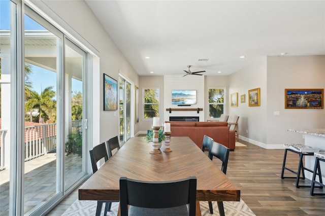 dining area with dark wood finished floors, recessed lighting, a fireplace, and baseboards