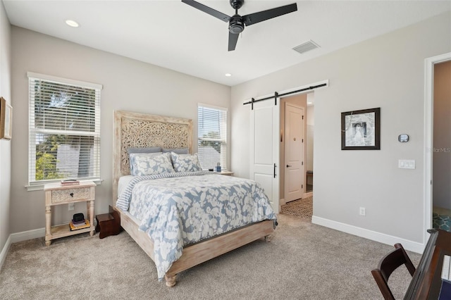 carpeted bedroom featuring visible vents, ceiling fan, baseboards, and a barn door