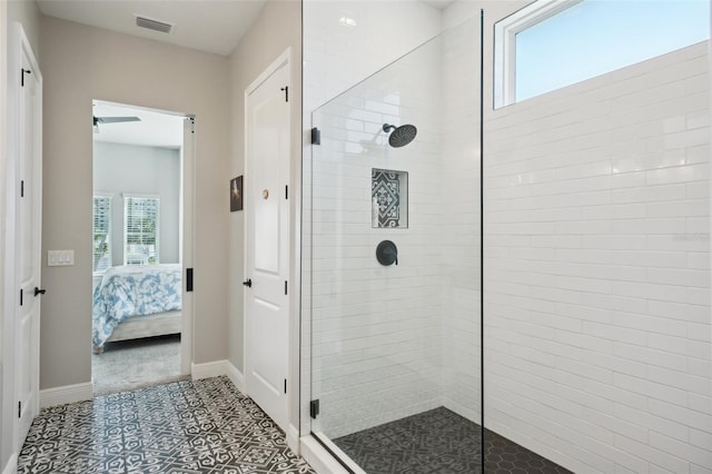 bathroom featuring tile patterned flooring, visible vents, connected bathroom, baseboards, and a tile shower