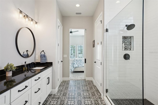 ensuite bathroom with visible vents, a tile shower, connected bathroom, baseboards, and vanity