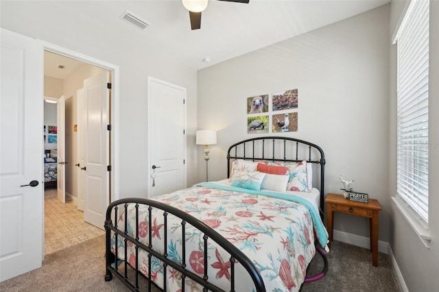 carpeted bedroom featuring visible vents, baseboards, and ceiling fan