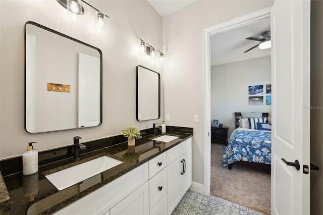 ensuite bathroom with ceiling fan, ensuite bath, double vanity, and a sink