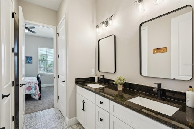 full bathroom with a sink, baseboards, ceiling fan, and double vanity