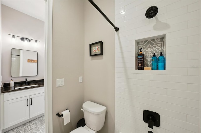 full bath featuring vanity, toilet, and tiled shower