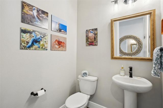 bathroom with baseboards and toilet