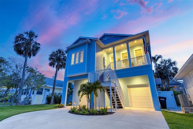 720 Bay Esplanade, Clearwater Beach, FL 33767 - raised beach house with stairway, driveway, an attached garage, and covered porch