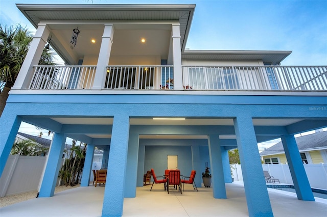 720 Bay Esplanade, Clearwater Beach, FL 33767 - rear view of property with a balcony, fence, a carport, and outdoor dining space
