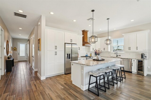 720 Bay Esplanade, Clearwater Beach, FL 33767 - kitchen featuring beverage cooler, appliances with stainless steel finishes, dark wood finished floors, a center island, and recessed lighting