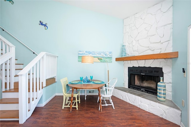 dining area with stairway, wood finished floors, and a fireplace