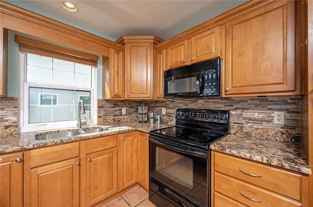 kitchen with tasteful backsplash, light tile patterned flooring, stone countertops, black appliances, and a sink