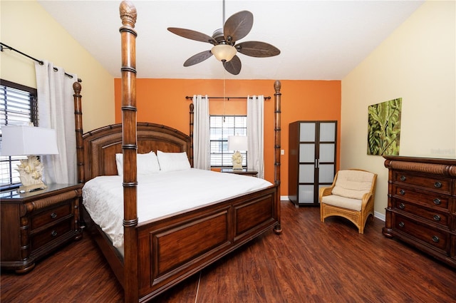 bedroom with dark wood finished floors, vaulted ceiling, and baseboards