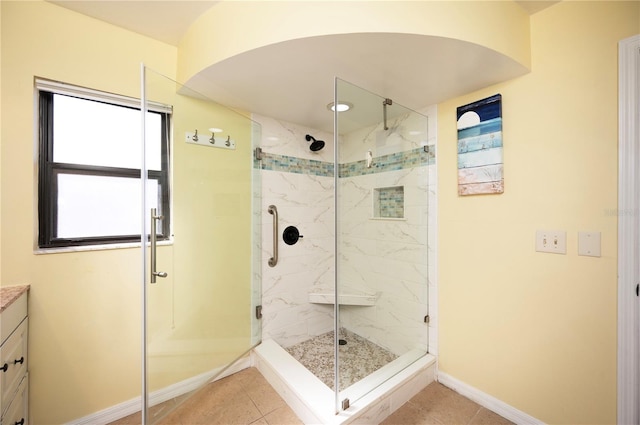 full bathroom with tile patterned floors, a marble finish shower, baseboards, and vanity