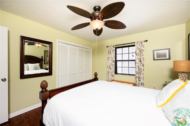 bedroom featuring a closet, a textured ceiling, baseboards, and wood finished floors