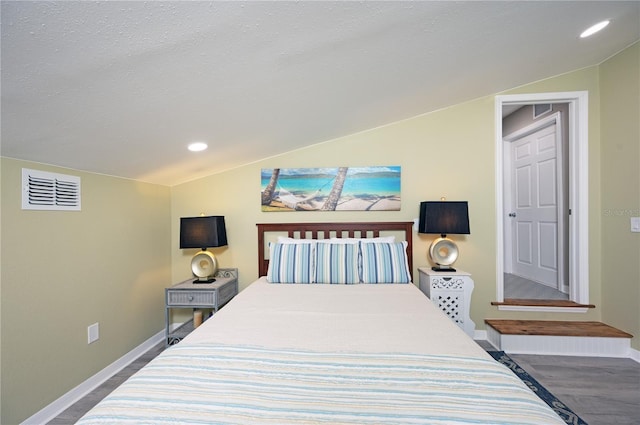 bedroom with visible vents, dark wood-type flooring, baseboards, lofted ceiling, and a textured ceiling