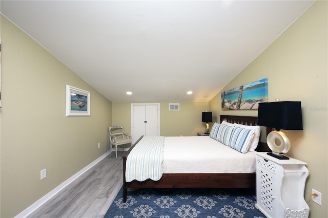 bedroom featuring visible vents, baseboards, vaulted ceiling, recessed lighting, and wood finished floors