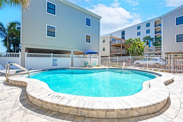 pool with a patio and fence