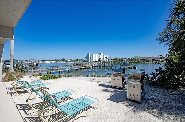 view of patio / terrace with a grill, a dock, and a water view