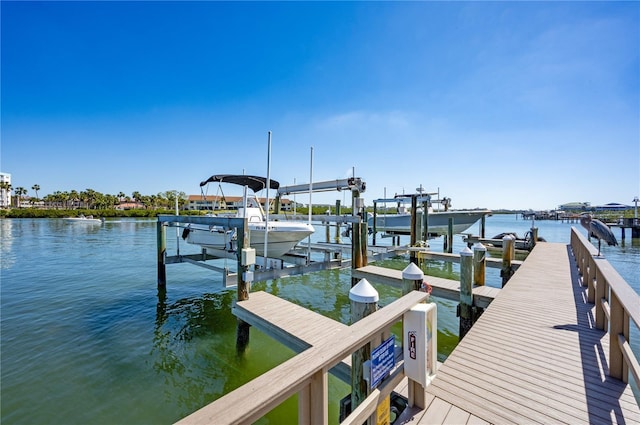 dock area featuring boat lift and a water view