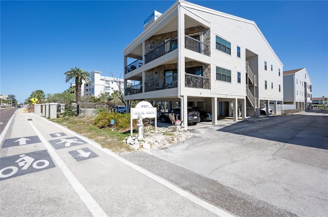 view of building exterior featuring covered and uncovered parking