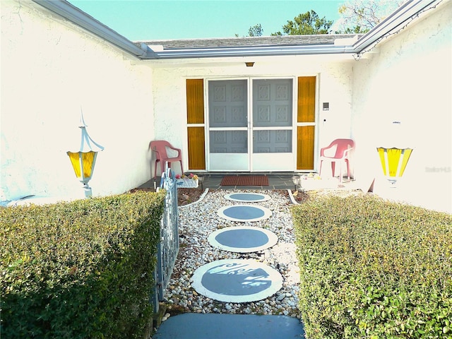 doorway to property featuring stucco siding