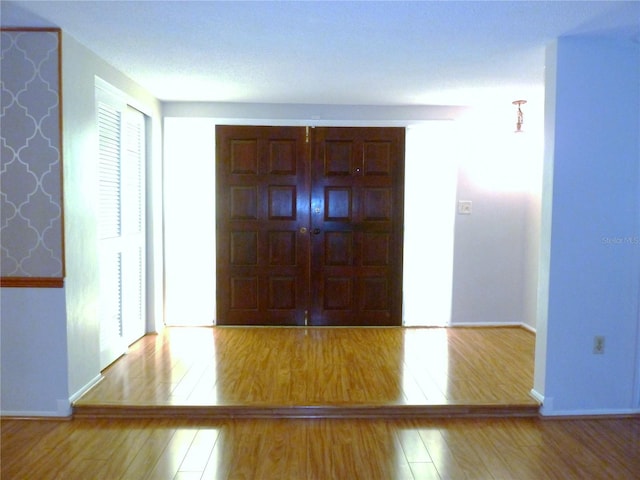 foyer entrance featuring baseboards and wood finished floors