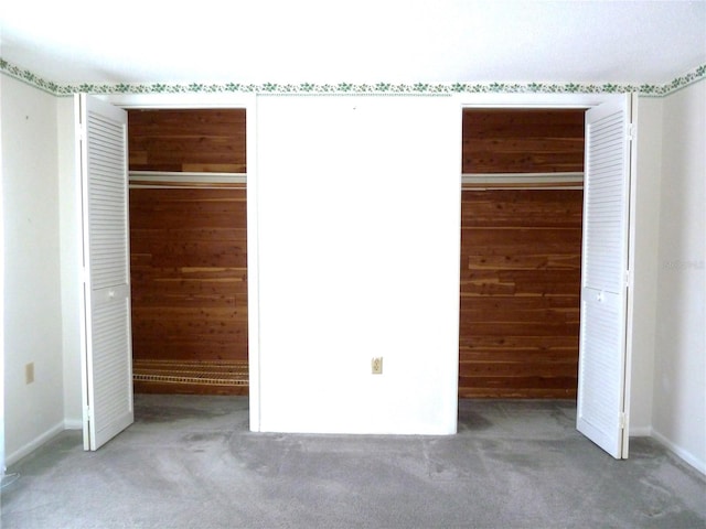 unfurnished bedroom featuring carpet floors and wood walls