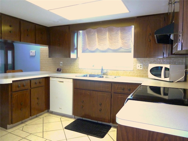 kitchen featuring a sink, tasteful backsplash, white appliances, exhaust hood, and light countertops