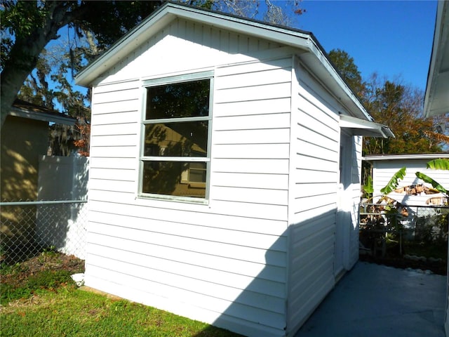 view of property exterior with an outbuilding and fence